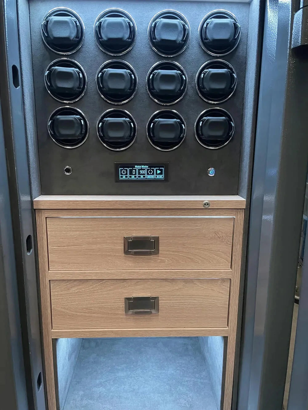 The Aevitas 12 Watch Winder Safe Grade 3 features a black panel with 12 round dials, digital keypad, two wooden drawers, sturdy metal frame, and offers a £350,000 insurance rating.