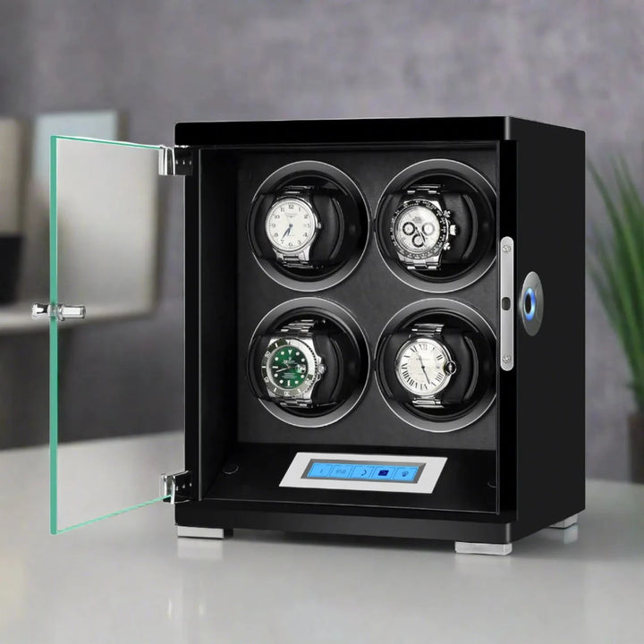 The Aevitas 4 Watch Winder from the Tower Series features a piano black wood finish, glass door, and digital control panel, beautifully displaying four automatic watches. It sits on a light surface with a blurred background.