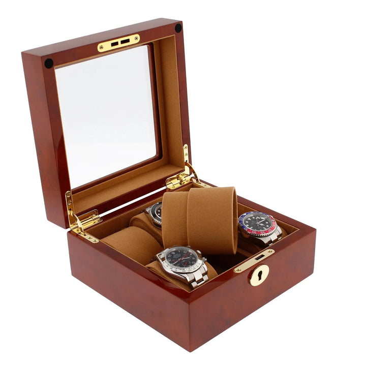 The open Aevitas 6 Watch Box in luxurious camphor wood with camel lining displays three luxury wristwatches in its compartments, with a gold-colored lock and a glass lid showcasing the elegant interior.