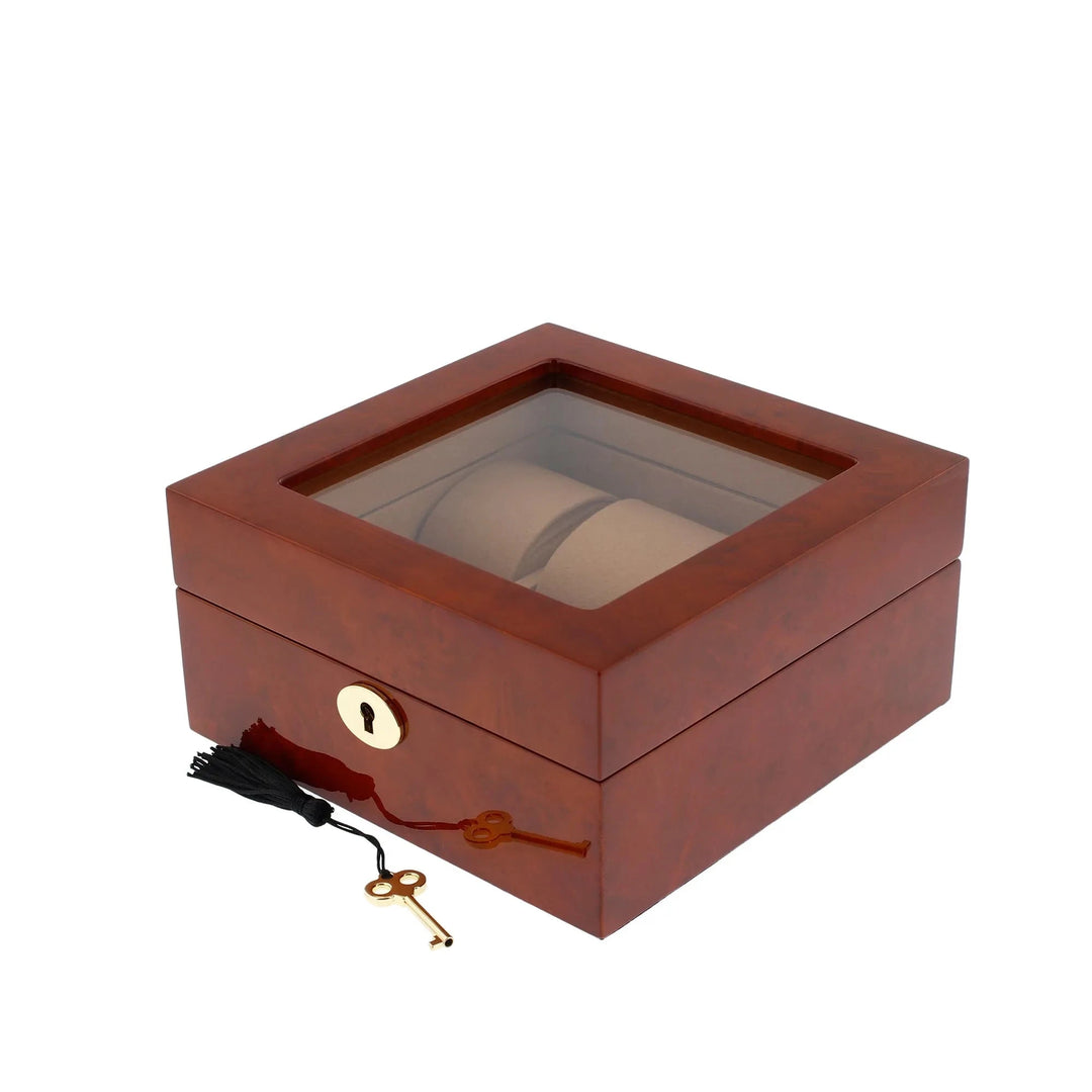 The Aevitas 6 Watch Box in luxurious camphor wood with camel lining features a glass top, front lock, and comes with a gold key with black tassel—an elegant, secure storage solution for your watch collection.