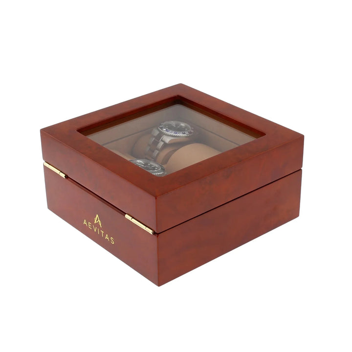 Aevitas offers a luxurious 6 watch box in glossy camphor wood with camel lining and glass top, featuring gold hinges and a refined printed logo on the front for an elegant display.