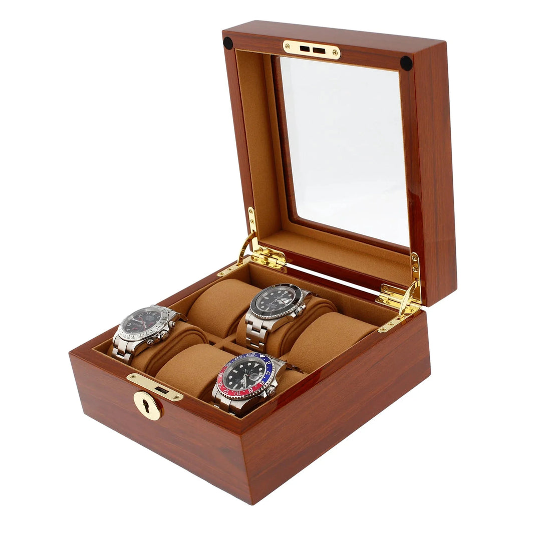 The 6 Watch Box in Luxurious Mahogany Wood with Camel Lining by Aevitas features a glass lid, gold hinges, and lock. Shown open against a white background, the box displays three metal wristwatches on tan cushions.