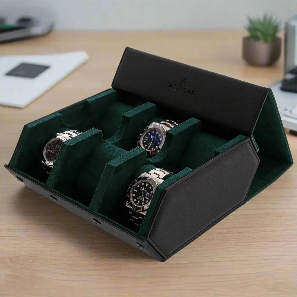 The Aevitas Watch Winders 6 Watch Travel Case in black leather with green lining (Hexagon Style) is open on a wooden desk among a plant, notebook, and phone—perfect as a watch gift box for organizing your collection.