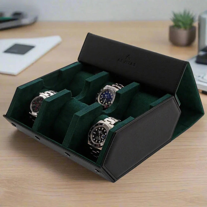 The Aevitas Watch Winders 6 Watch Travel Case in black leather with green lining (Hexagon Style) is open on a wooden desk among a plant, notebook, and phone—perfect as a watch gift box for organizing your collection.
