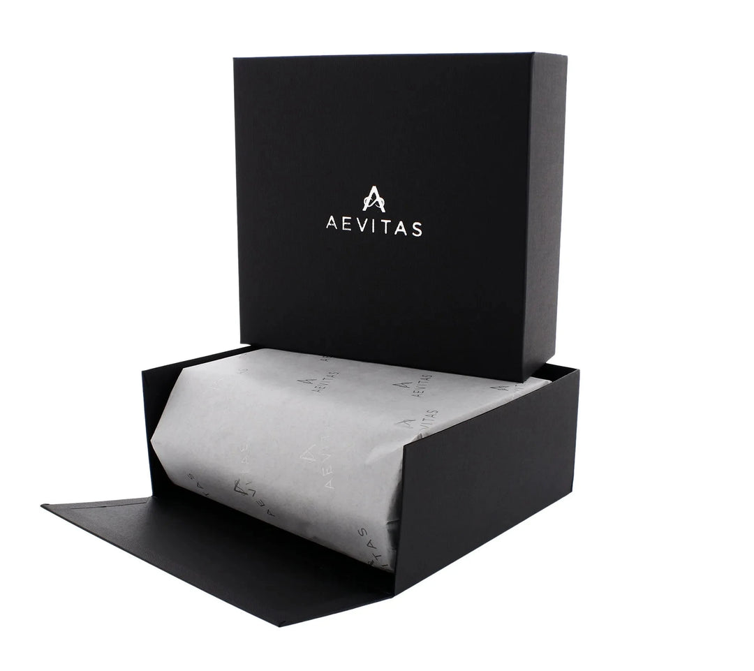 A black Aevitas Watch Winders gift box opens to reveal tissue-wrapped contents, perfect for gifting. The hinged lid displays the logo inside—ideal for presenting the 6 Watch Travel Case in Black Leather with Grey Lining, Hexagon Style.