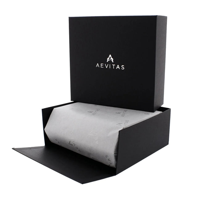 A black Aevitas Watch Winders gift box opens to reveal tissue-wrapped contents, perfect for gifting. The hinged lid displays the logo inside—ideal for presenting the 6 Watch Travel Case in Black Leather with Grey Lining, Hexagon Style.