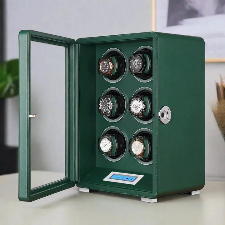 The Automatic 6 Watch Winder Dark Green Smooth Leather Finish by Aevitas displays six wristwatches in rotating slots behind an open glass door, with a digital control panel, elegantly set on a light-colored surface.
