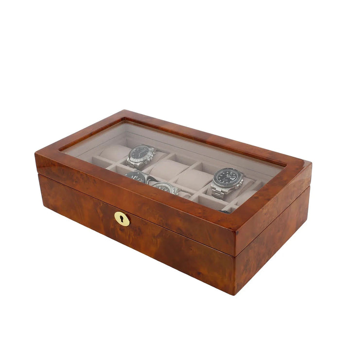 The Aevitas Watch Box for 12 Wrist Watches in Burl Walnut Wood features a glass top to display your collection, individual compartments, and a front lock for secure luxury storage.